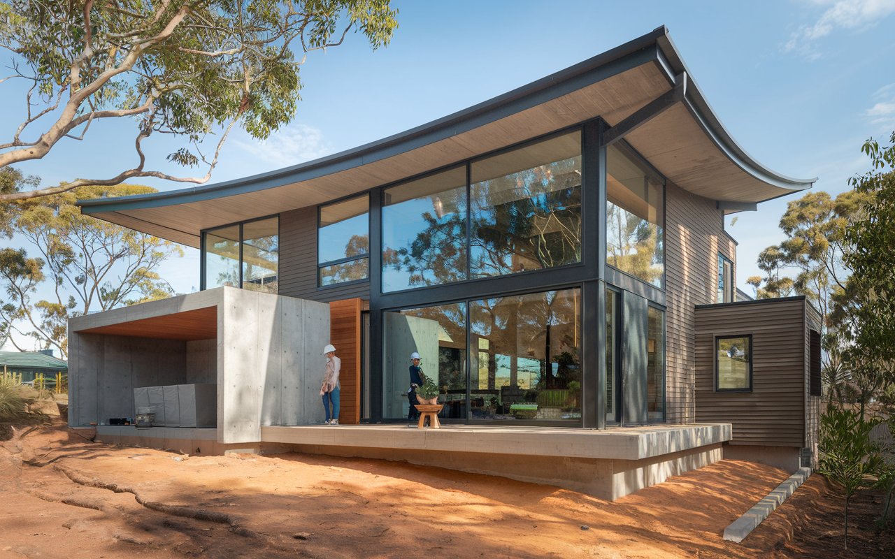 - Aussie Build Estimates Modern house with large windows and patio; two people outside, stressing pest inspection for renovations.